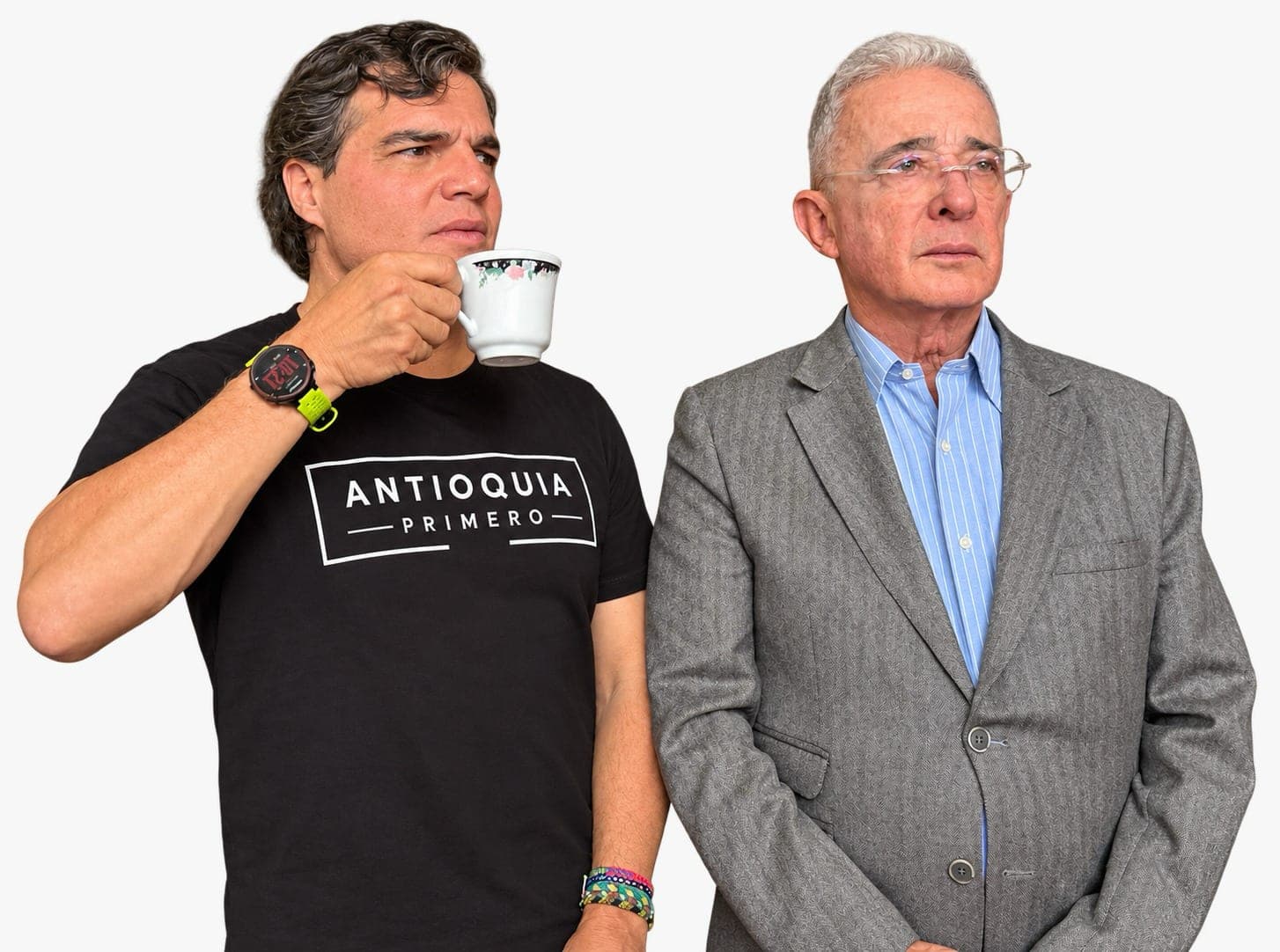 Alejandro Arbeláez A., con camiseta negra «Antioquia Primero» y un pocillo de café, de pie junto a Álvaro Uribe Vélez, sobre fondo claro