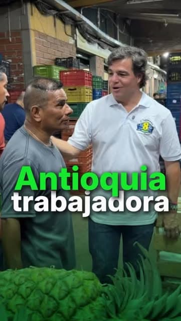 Alejandro Arbeláez conversa con un trabajador entre puestos de frutas y verduras en La Mayorista